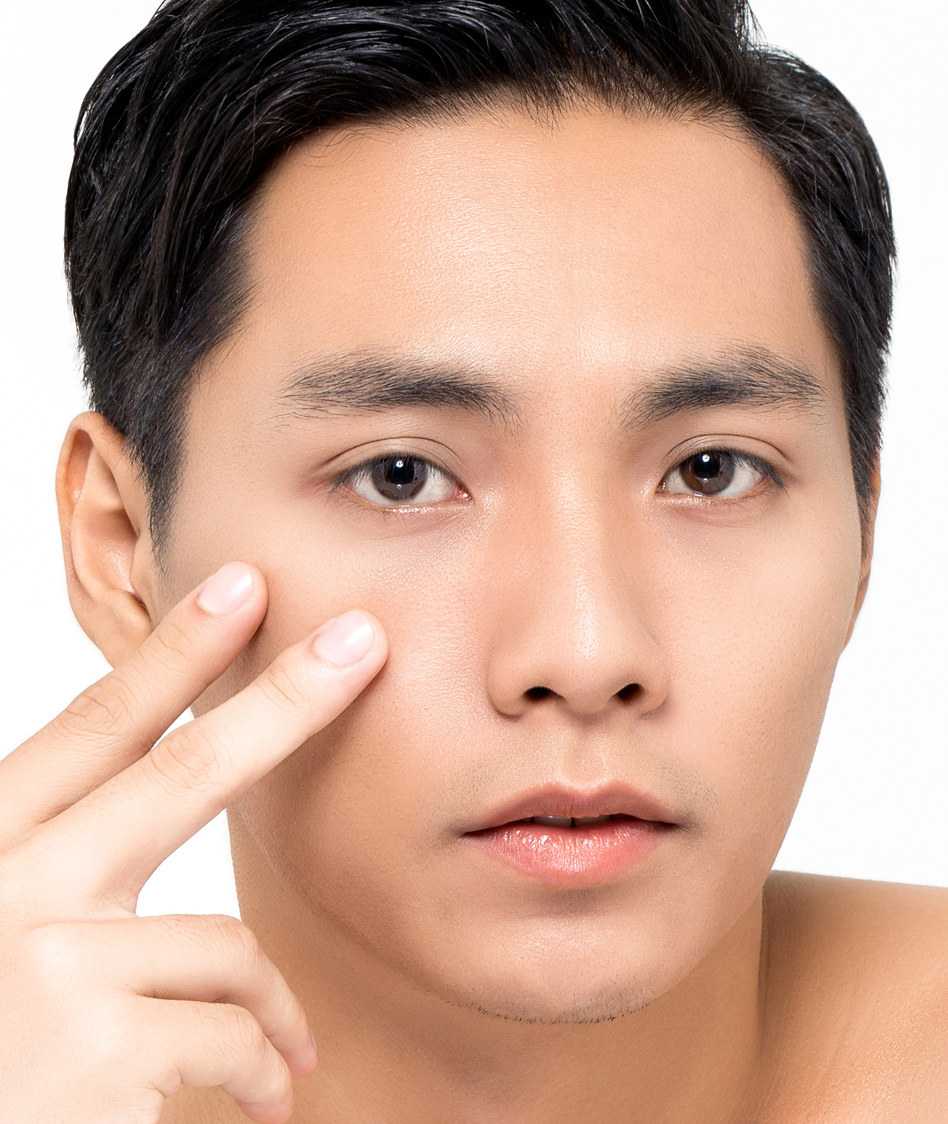 Joven asiatico cuidando la piel del contorno de ojos